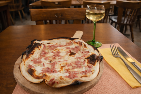 Flammkuchen im Elsass mit Weißwein im traditionellen Elsässer Weinglas
