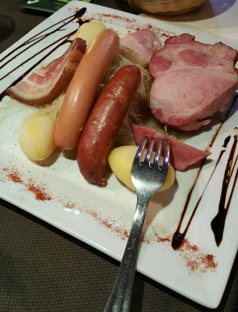 Choucroute mit Wurst, Kassler und Kartoffeln auf einem traditionellen Teller