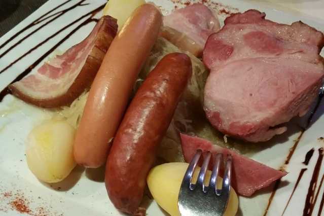 Choucroute mit Wurst, Kassler und Kartoffeln auf einem traditionellen Teller