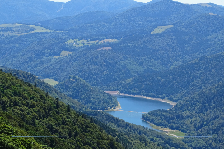 Blick auf den Lac de Kruth-Wildenstein in den südlichen Vogesen, umgeben von dicht bewaldeten Berghängen