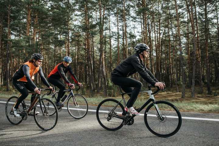 Radfahrer auf einer ruhigen Waldstraße während einer Fahrradtour in den Vogesen