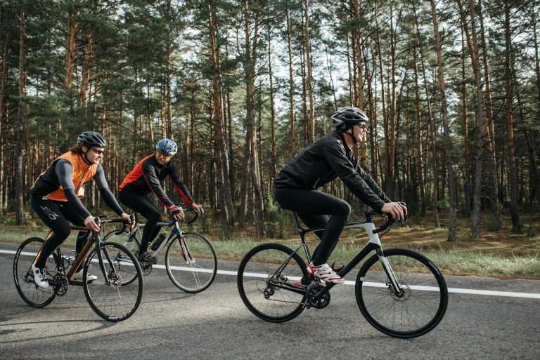 Radfahrer auf einer ruhigen Waldstraße während einer Fahrradtour in den Vogesen