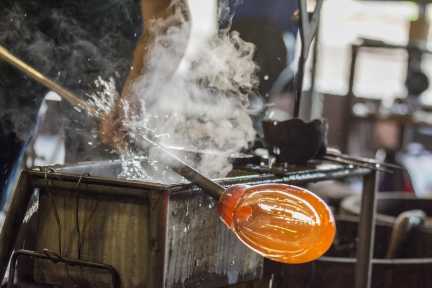 Glasherstellung in einer Manufaktur im Elsass – heißes Glas wird von Hand bearbeitet